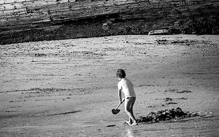 Photo en noir et blanc de Marilg : un petit garçon joue sur une plage